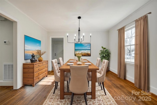 dining space featuring a chandelier, dark wood-style flooring, visible vents, and crown molding