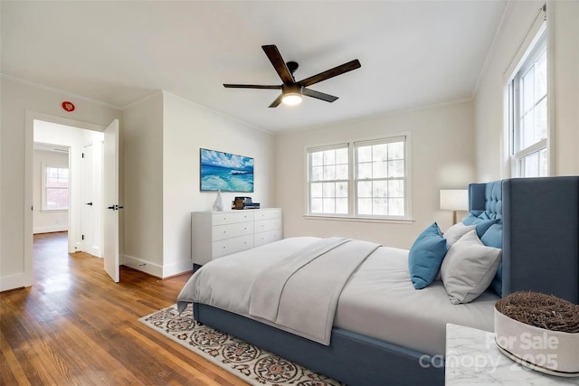 bedroom with crown molding, baseboards, and wood finished floors