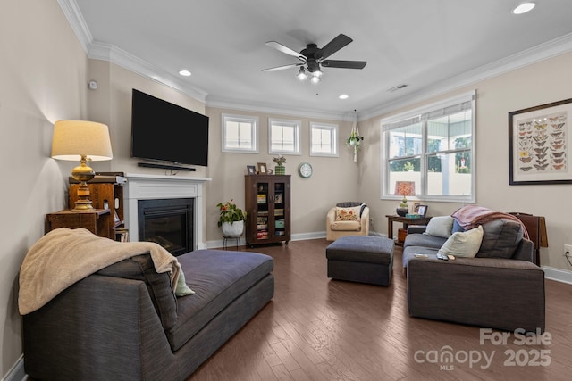 living room featuring baseboards, hardwood / wood-style flooring, visible vents, and crown molding