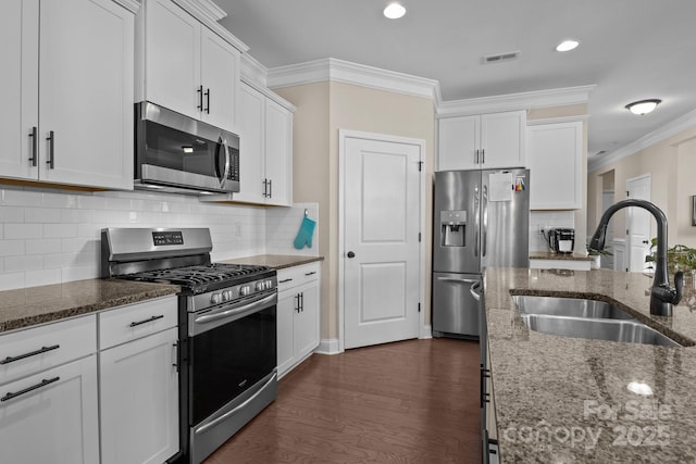 kitchen featuring crown molding, stainless steel appliances, visible vents, white cabinetry, and a sink