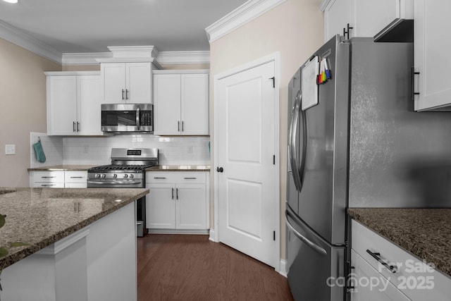 kitchen with appliances with stainless steel finishes, white cabinets, and crown molding