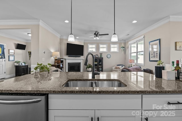 kitchen with open floor plan, dark stone countertops, a sink, a fireplace, and stainless steel dishwasher