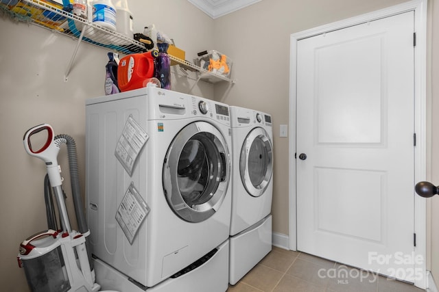 clothes washing area featuring laundry area, washer and clothes dryer, and light tile patterned flooring