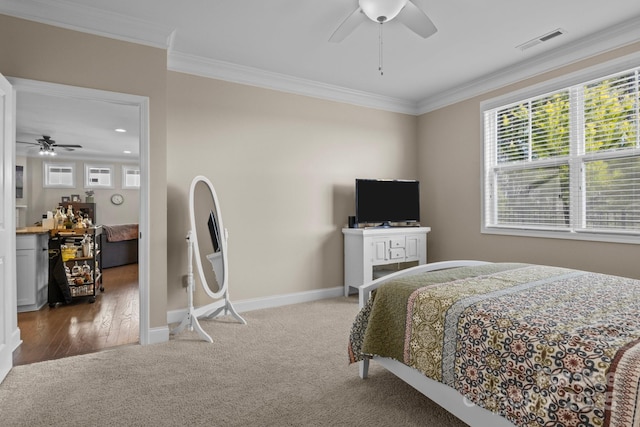 bedroom featuring carpet floors, visible vents, ornamental molding, ceiling fan, and baseboards