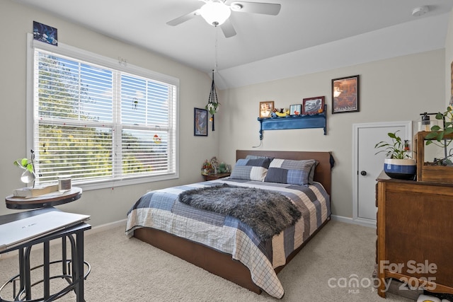 carpeted bedroom featuring a ceiling fan, lofted ceiling, and baseboards