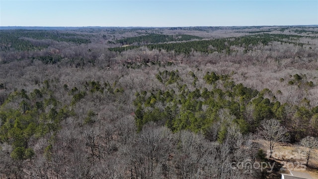 drone / aerial view with a wooded view