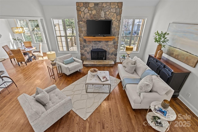 living room with a fireplace, wood finished floors, and baseboards