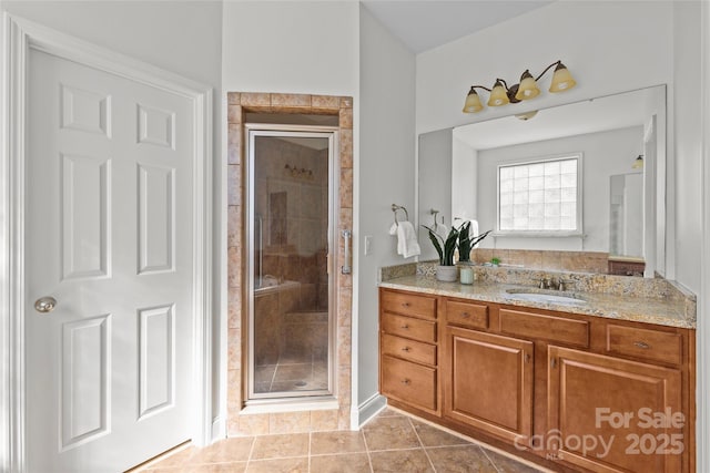 bathroom with a stall shower, vanity, and tile patterned floors