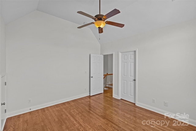 unfurnished bedroom featuring lofted ceiling, ceiling fan, baseboards, and wood finished floors