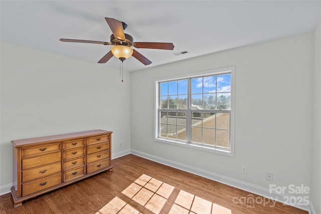 unfurnished bedroom with ceiling fan, wood finished floors, visible vents, and baseboards