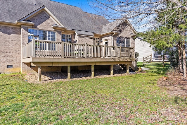 back of property featuring a yard, brick siding, roof with shingles, and crawl space