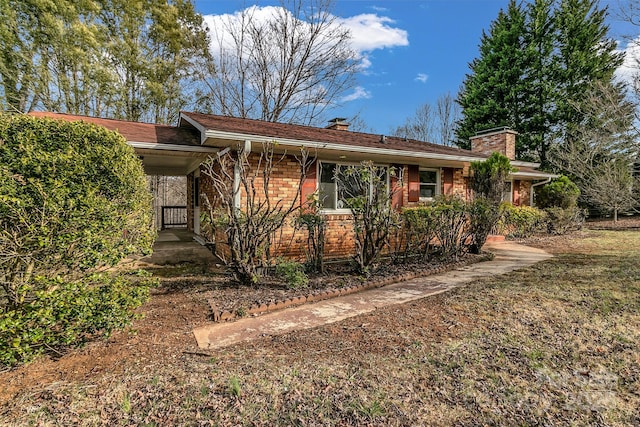 single story home with brick siding and a chimney