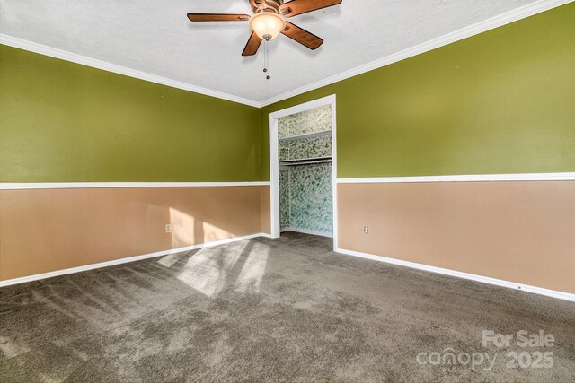 carpeted spare room with ceiling fan, a textured ceiling, crown molding, and baseboards