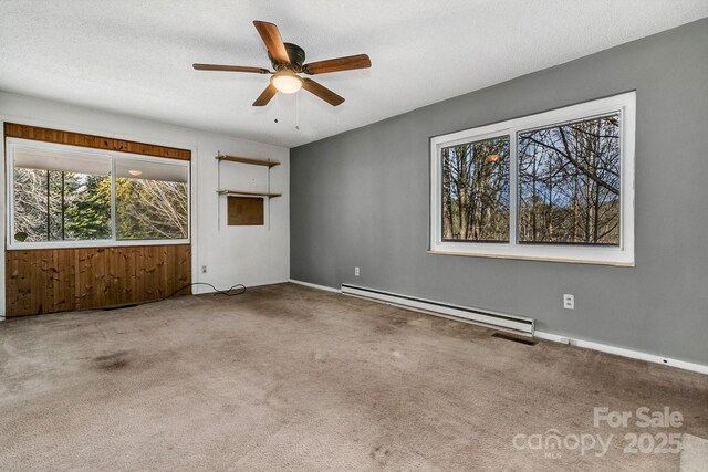 spare room with a textured ceiling, baseboard heating, ceiling fan, and carpet