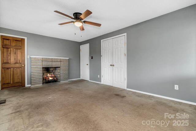 unfurnished living room with a brick fireplace, visible vents, baseboards, and carpet floors