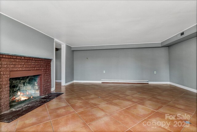 unfurnished living room with tile patterned floors, baseboards, baseboard heating, and a brick fireplace