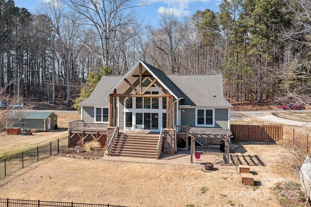 rear view of property featuring an outdoor fire pit, a fenced backyard, roof with shingles, stairway, and a wooden deck