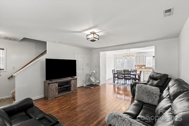 living area with stairway, dark wood-style flooring, and visible vents