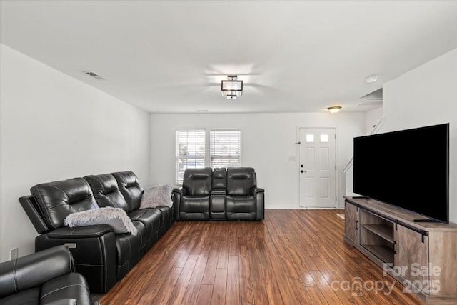 living area with dark wood-style flooring and visible vents