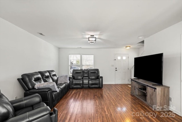 living room featuring baseboards, visible vents, and dark wood finished floors