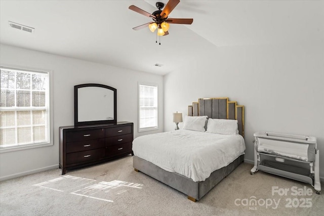 bedroom featuring light colored carpet, visible vents, lofted ceiling, and baseboards