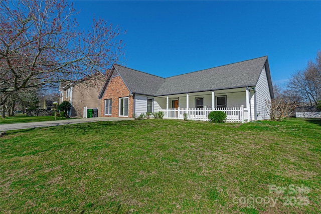 ranch-style home featuring a front yard, brick siding, and a shingled roof