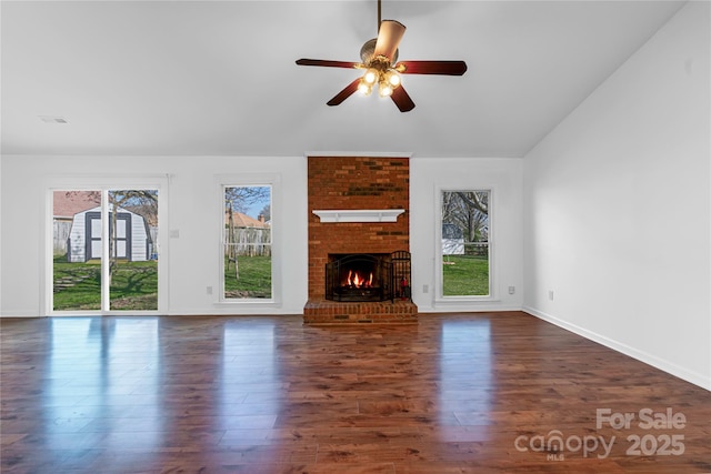 unfurnished living room with a ceiling fan, baseboards, dark wood-type flooring, and a fireplace