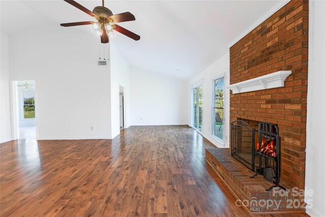 unfurnished living room featuring a brick fireplace, baseboards, ceiling fan, wood finished floors, and high vaulted ceiling