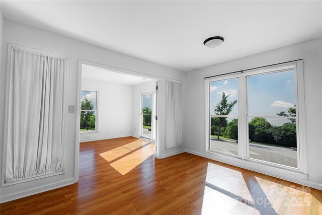 empty room with baseboards and wood finished floors