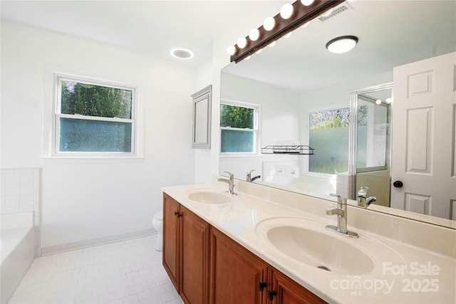 full bath featuring a bath, tile patterned floors, double vanity, and a sink