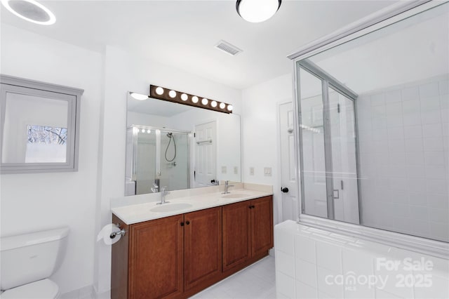 bathroom with visible vents, toilet, a sink, a shower stall, and double vanity