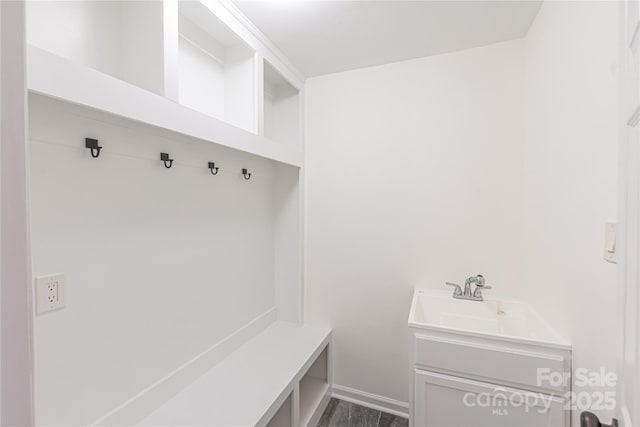 mudroom with baseboards and a sink