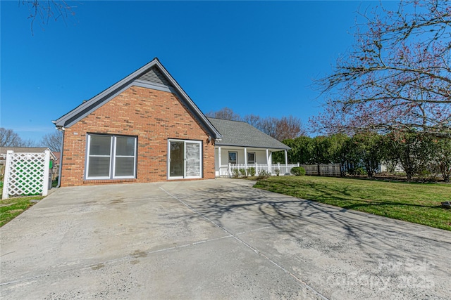 view of front of property with a front yard, fence, and brick siding