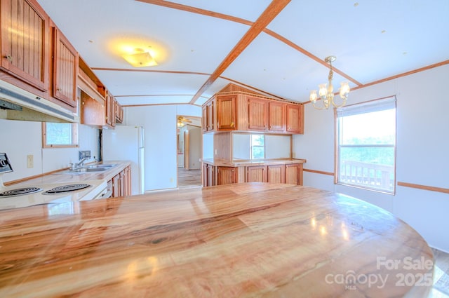 kitchen with lofted ceiling, a notable chandelier, white appliances, brown cabinetry, and decorative light fixtures