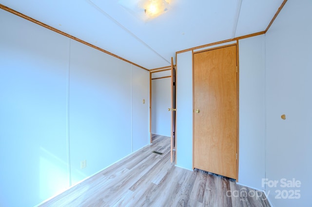 unfurnished bedroom with light wood-type flooring and a closet