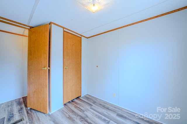 unfurnished bedroom featuring light wood-style flooring and a closet