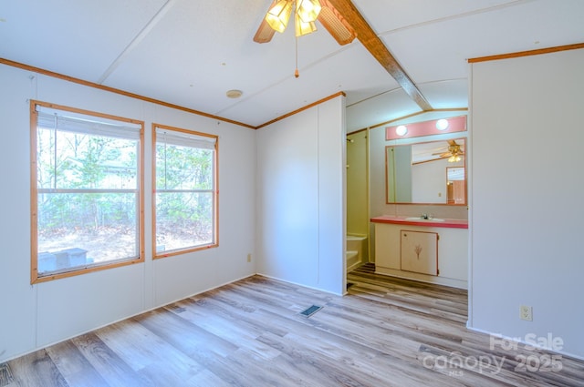 unfurnished room featuring light wood finished floors, visible vents, lofted ceiling with beams, a sink, and ceiling fan