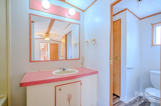 bathroom with vaulted ceiling, crown molding, vanity, and toilet