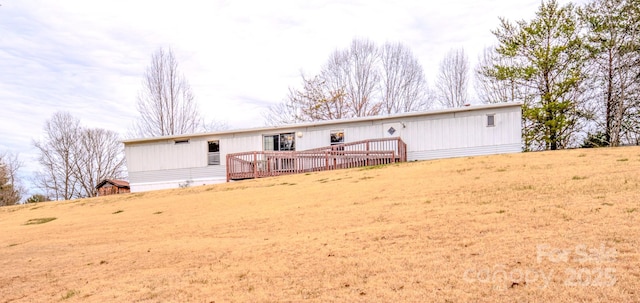 rear view of property with a lawn and a wooden deck