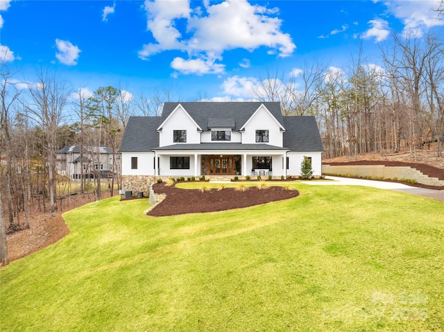 modern farmhouse style home with driveway, covered porch, and a front lawn