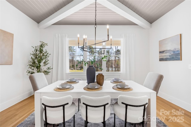 dining room with light wood-style floors, baseboards, a chandelier, and beam ceiling