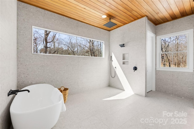 full bathroom featuring tile walls, a freestanding tub, wood ceiling, and tile patterned floors