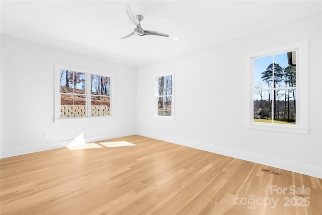 spare room with a ceiling fan, visible vents, light wood-style flooring, and baseboards