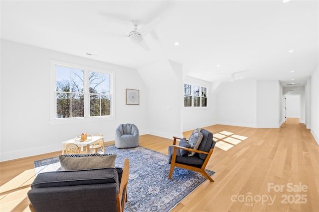 sitting room with a ceiling fan, light wood-style flooring, and baseboards