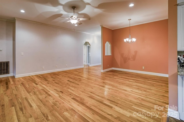 empty room featuring light wood-type flooring, visible vents, and ornamental molding