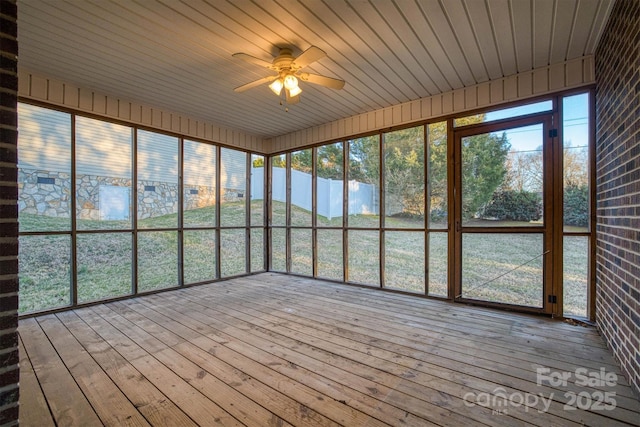 unfurnished sunroom with a water view, a ceiling fan, and a healthy amount of sunlight