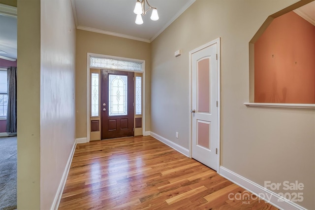 entryway with baseboards, light wood finished floors, plenty of natural light, and crown molding