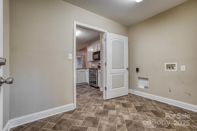 laundry area with laundry area, hookup for a washing machine, and baseboards