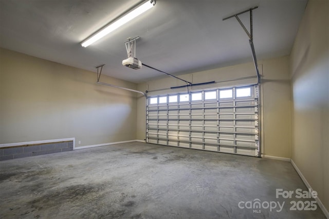 garage with a garage door opener and baseboards