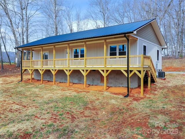 rear view of house featuring metal roof and cooling unit